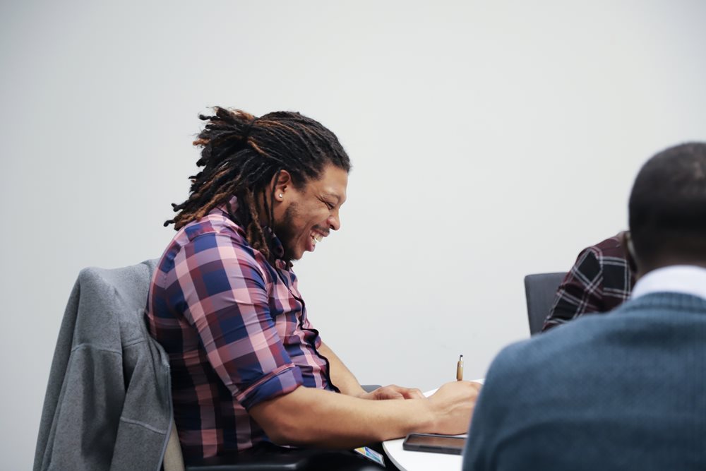Image of Zephaniah Manning collaborating with colleagues in a meeting.